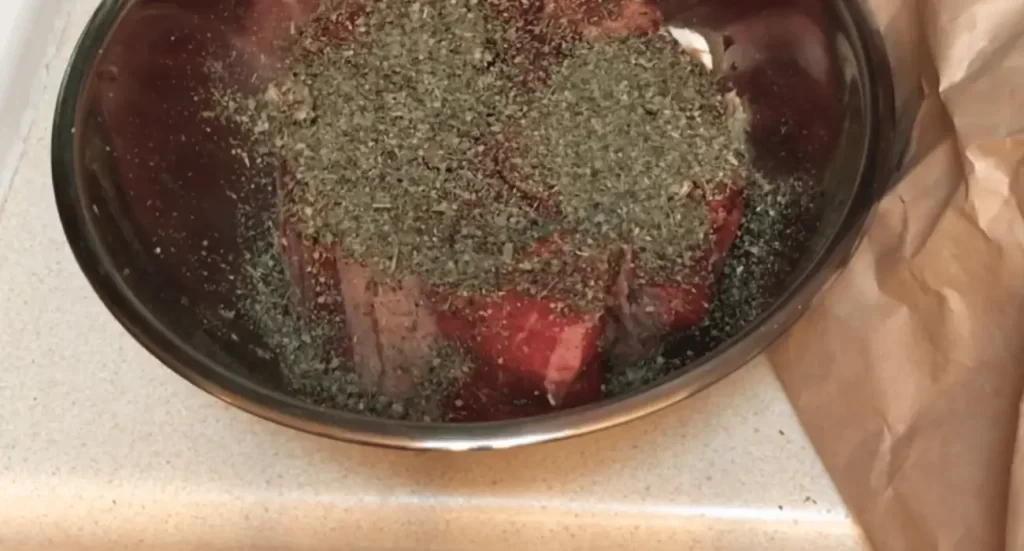 Beef chuck roast being seared in a hot skillet. 