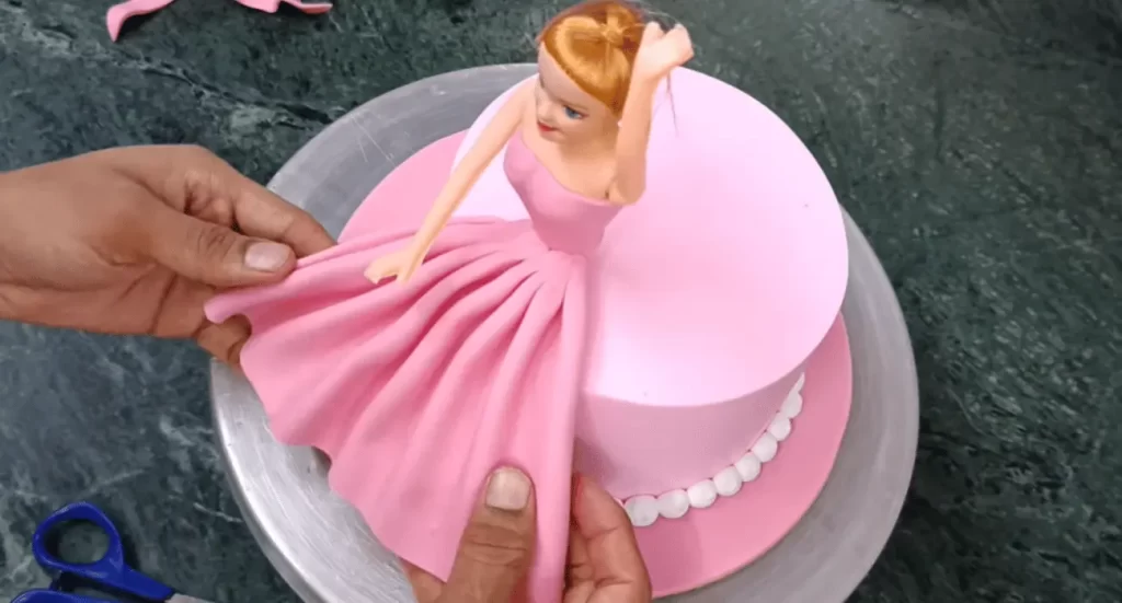 Colorful Barbie cake topper on a beautifully decorated cake