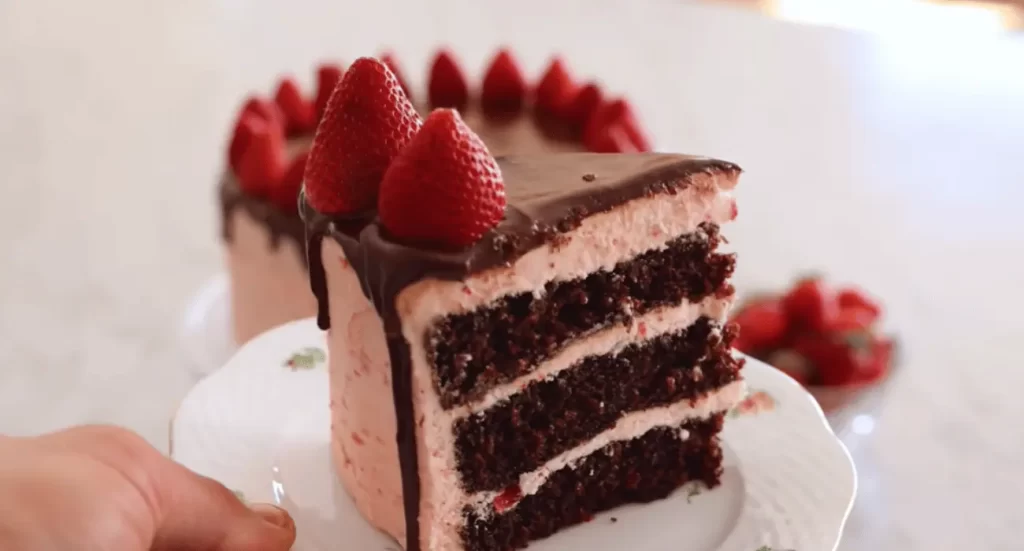 The photo captures a beautifully decorated whole strawberry chocolate cake, covered in a smooth chocolate ganache and adorned with fresh strawberries. The cake's elegant presentation makes it a stunning centerpiece for celebrations