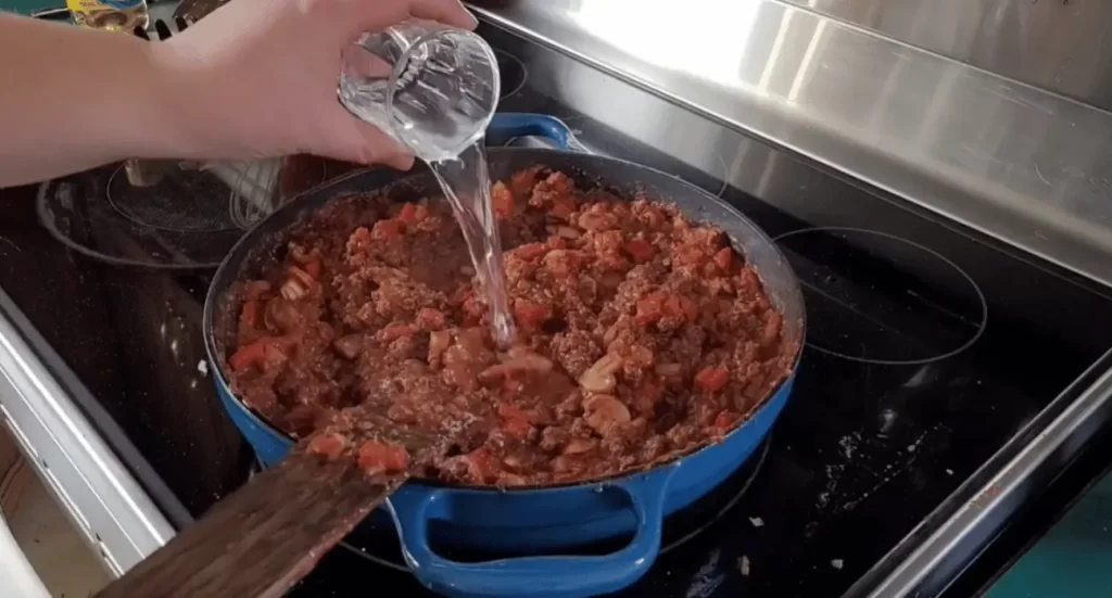 Bowl of hearty venison chili garnished with sour cream and fresh cilantro.