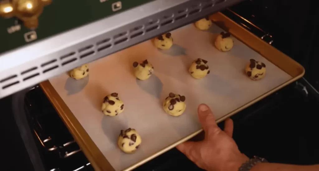 Nestle chocolate chip cookies arranged on a plate with a glass of milk.