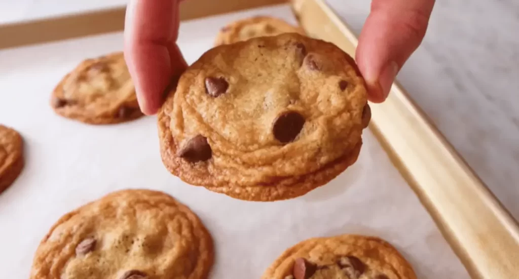 Nestle chocolate chip cookies with a few cookies broken to show the gooey chocolate center.